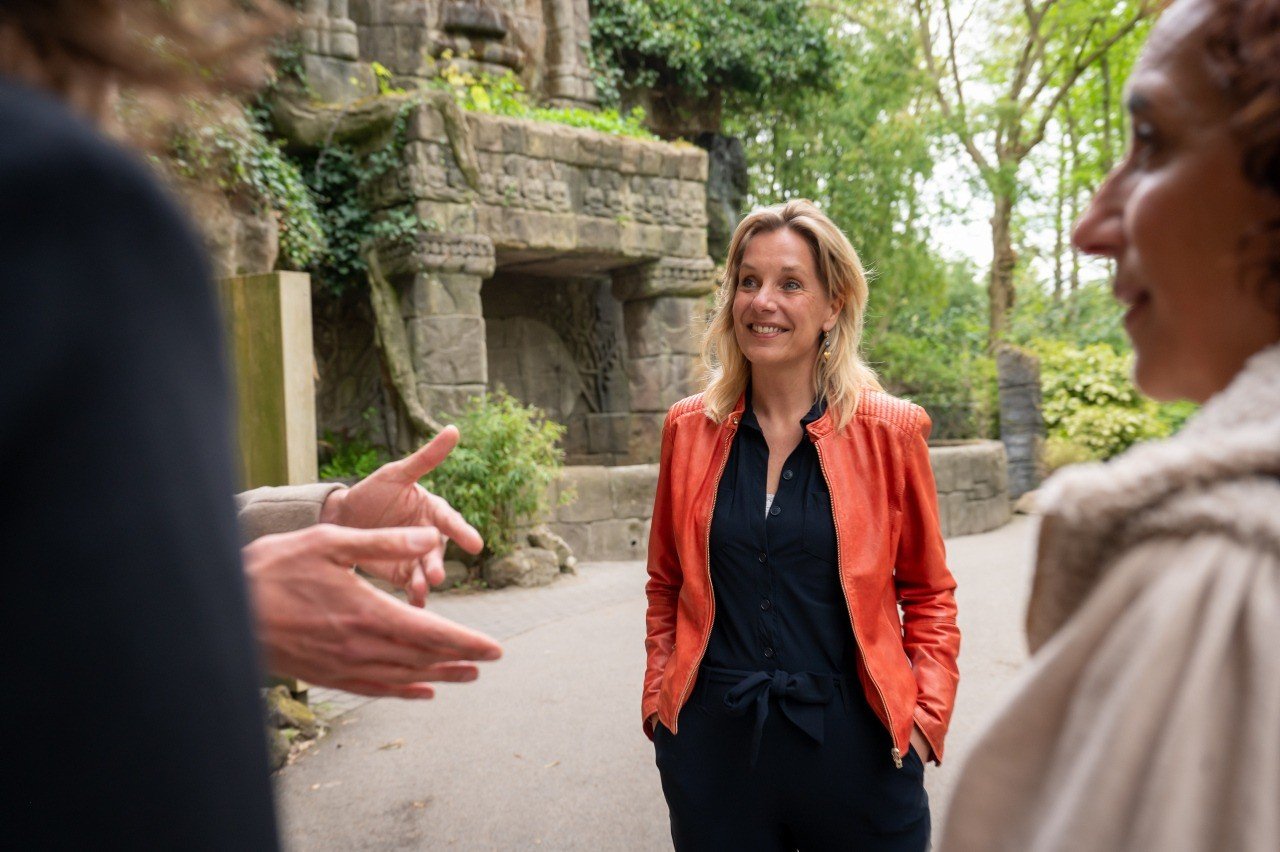Carolien Ottjes in gesprek met twee mensen op een pad in Diergaarde Blijdorp.