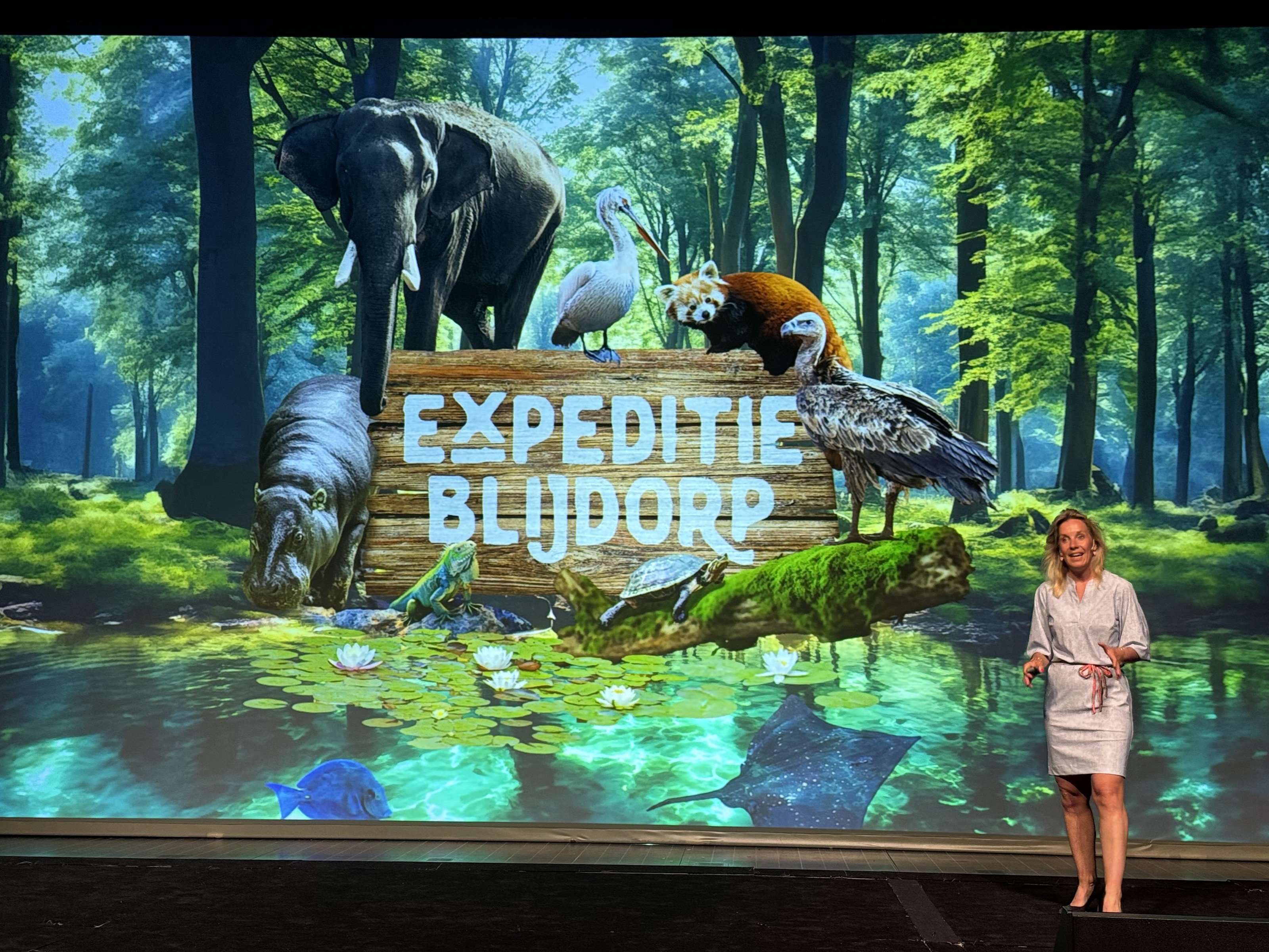 Carolien Ottjes op een groot podium voor een scherm met de tekst Expeditie Blijdorp.