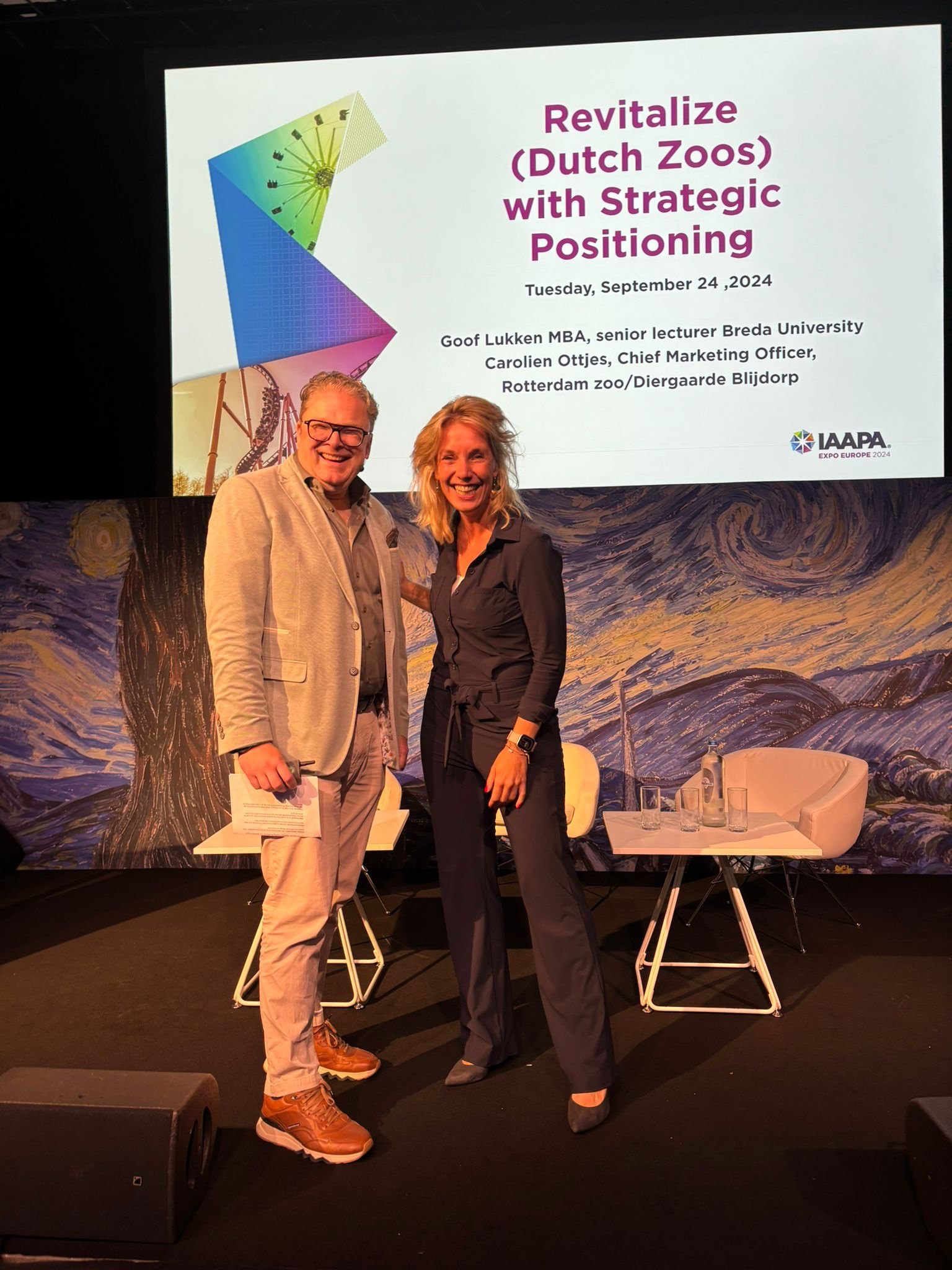 Carolien Ottjes na haar presentatie op IAAPA, naast het scherm met de titel Revitalize (Dutch) Zoos with Strategic Positioning.